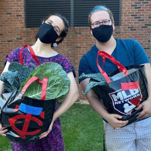 Natalie Jacobson and a student holding tote bags of groceries